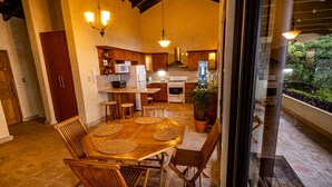 A spacious kitchen with wooden cabinets, a central island, and a dining area with a large wooden table and chairs. - Casa Cholotío lake view, modern, beach access (Panajachel)