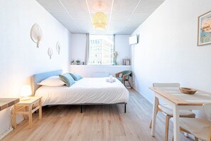Une chambre à coucher moderne avec un lit, une table de chevet, une chaise et une petite table sur laquelle se trouve un bol.