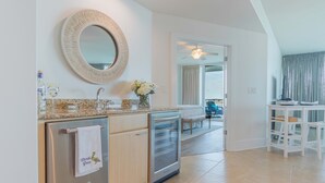 A modern kitchen with a built-in oven, a refrigerator, and a microwave. There is a large mirror above the sink and a vase with flowers on the countertop. - Newly Remodeled 3 Bedroom with Views of Robinson Island and Perdido Bay. Complimentary Boat Slip! (Orange Beach)