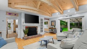A spacious living room with a fireplace, a television, and a comfortable seating area.