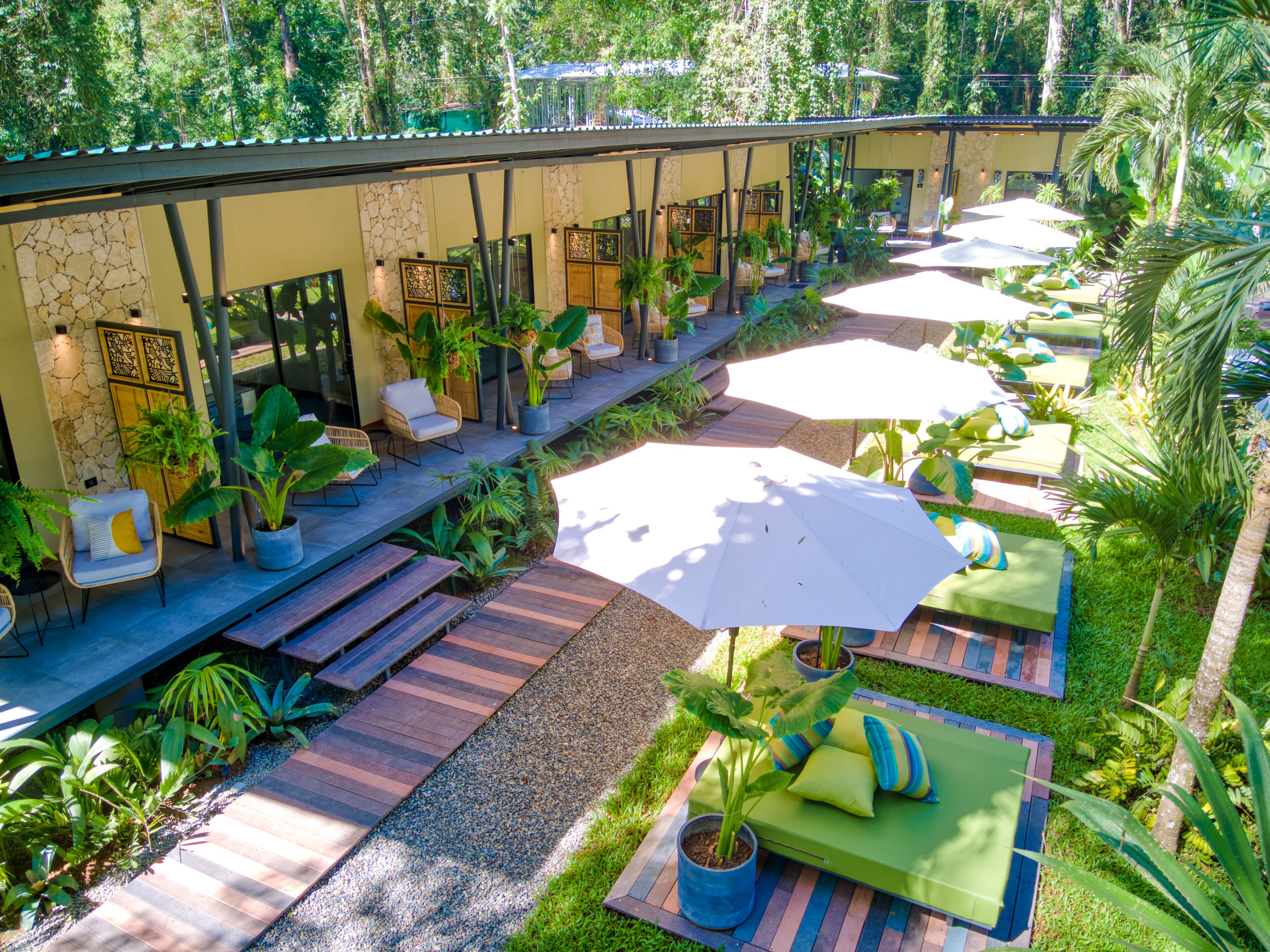 A resort with outdoor seating areas, covered walkways, and lush greenery.
