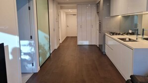 A modern kitchen with white cabinets, a stainless steel sink, and a gas stove.