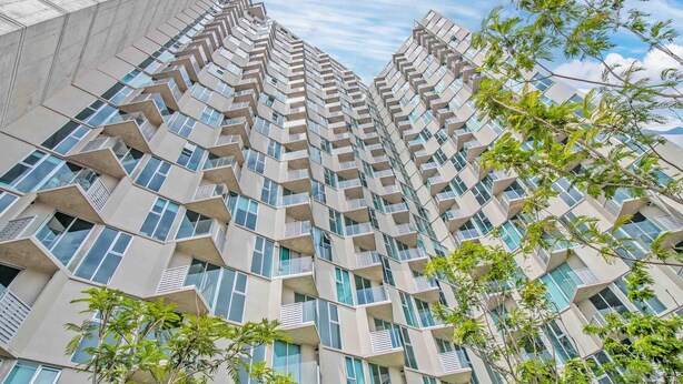 A high-rise building with a unique angular design, featuring multiple balconies and large windows.
