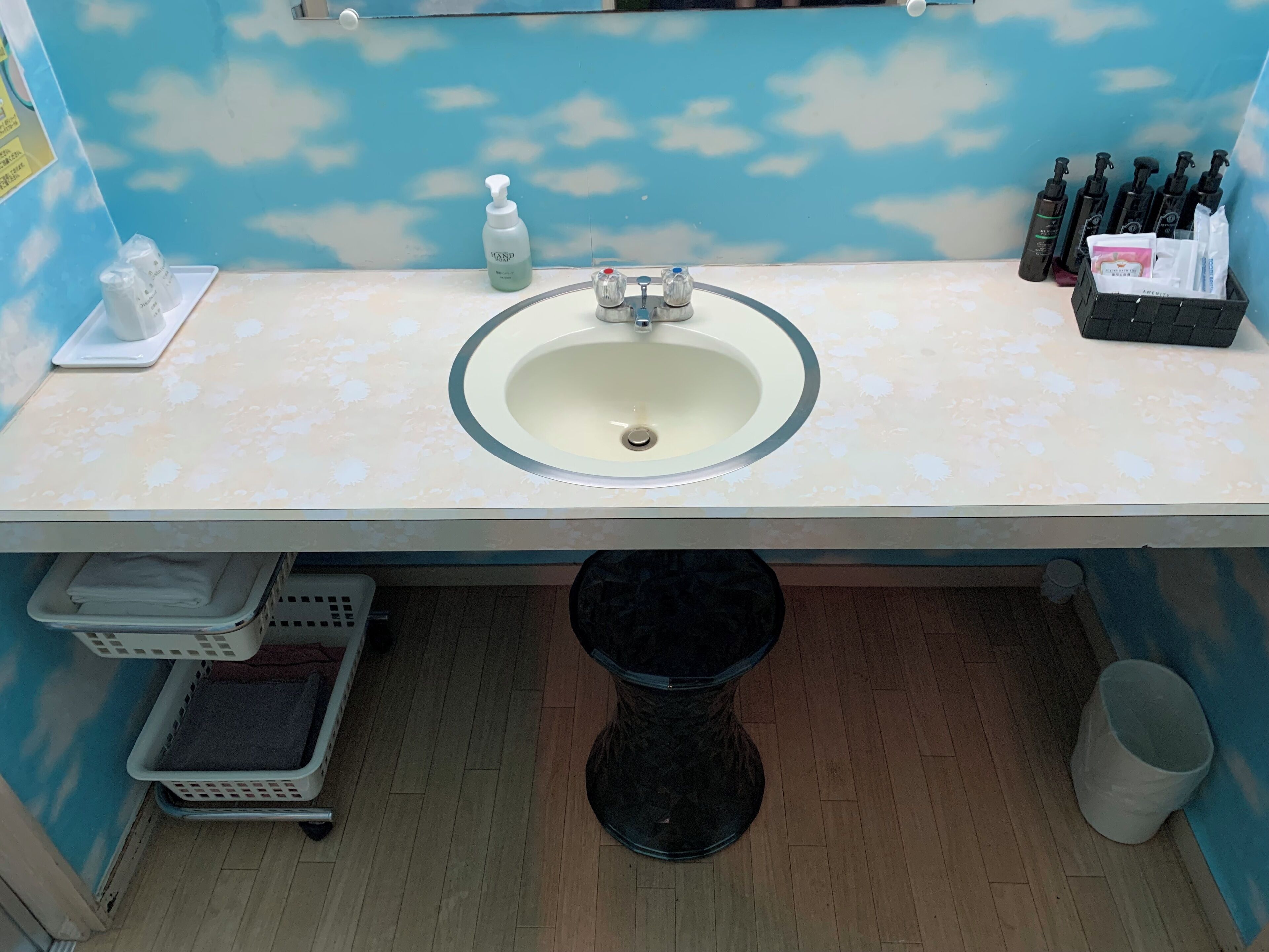 A bathroom with a sink, hand soap, and toiletries.
