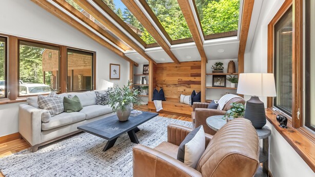 A spacious living room with a high ceiling, wooden beams, large windows, and a cozy seating area with a coffee table and sofas. - Carpe Montem - Modern, Views, Large Deck, Hot Tub, Private (Sundance)