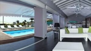 Een modern interieur met een zwembad, een loungehoek en een eethoek.