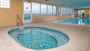 A swimming pool with a hot tub, a lifeguard chair, and a no-entry sign.