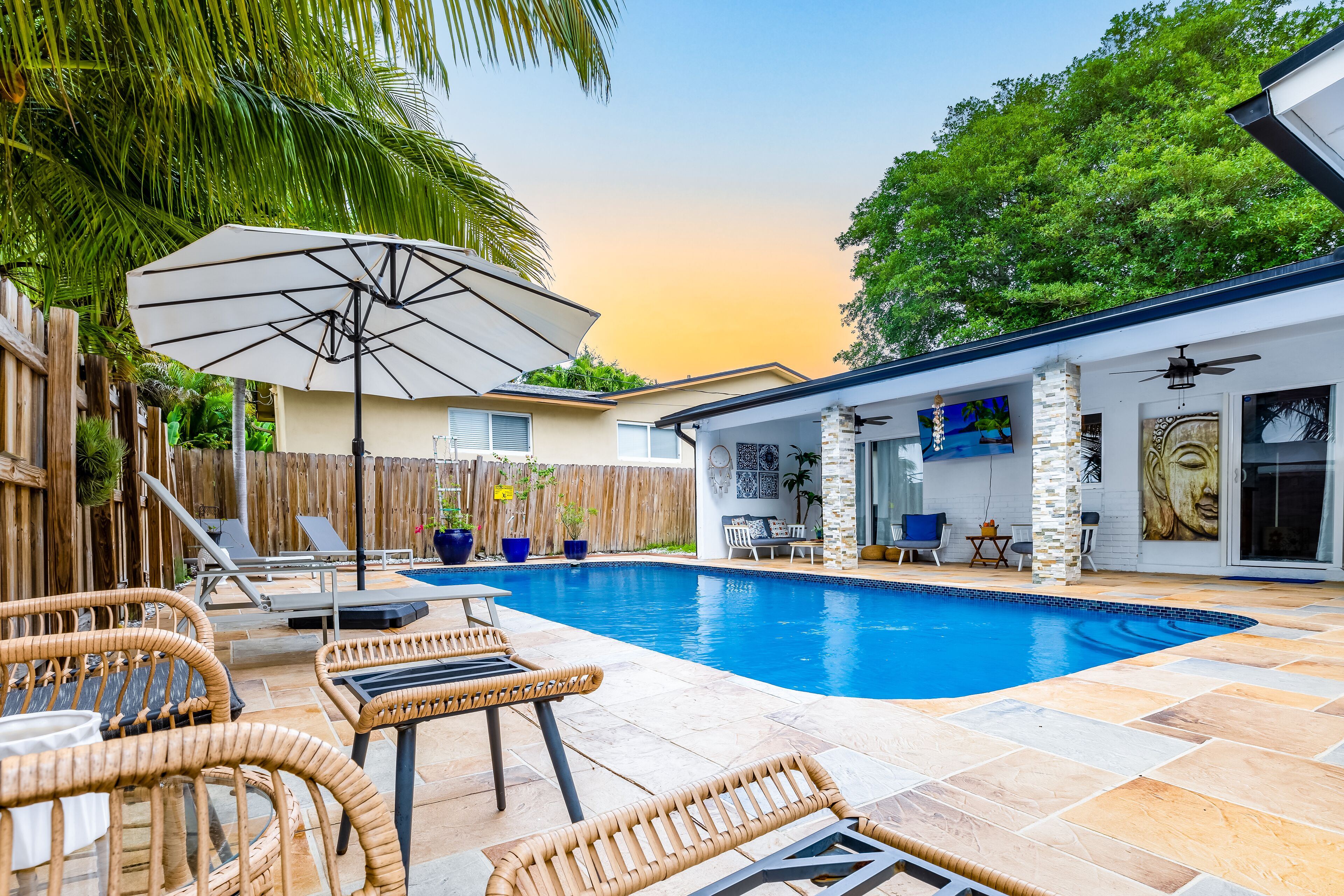 Un jardin avec une piscine, des chaises longues et un espace patio.