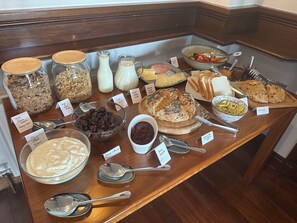 A breakfast buffet with various food items and labels.