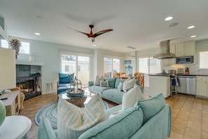 A spacious living area with a fireplace, a dining table, and a kitchen with modern appliances.