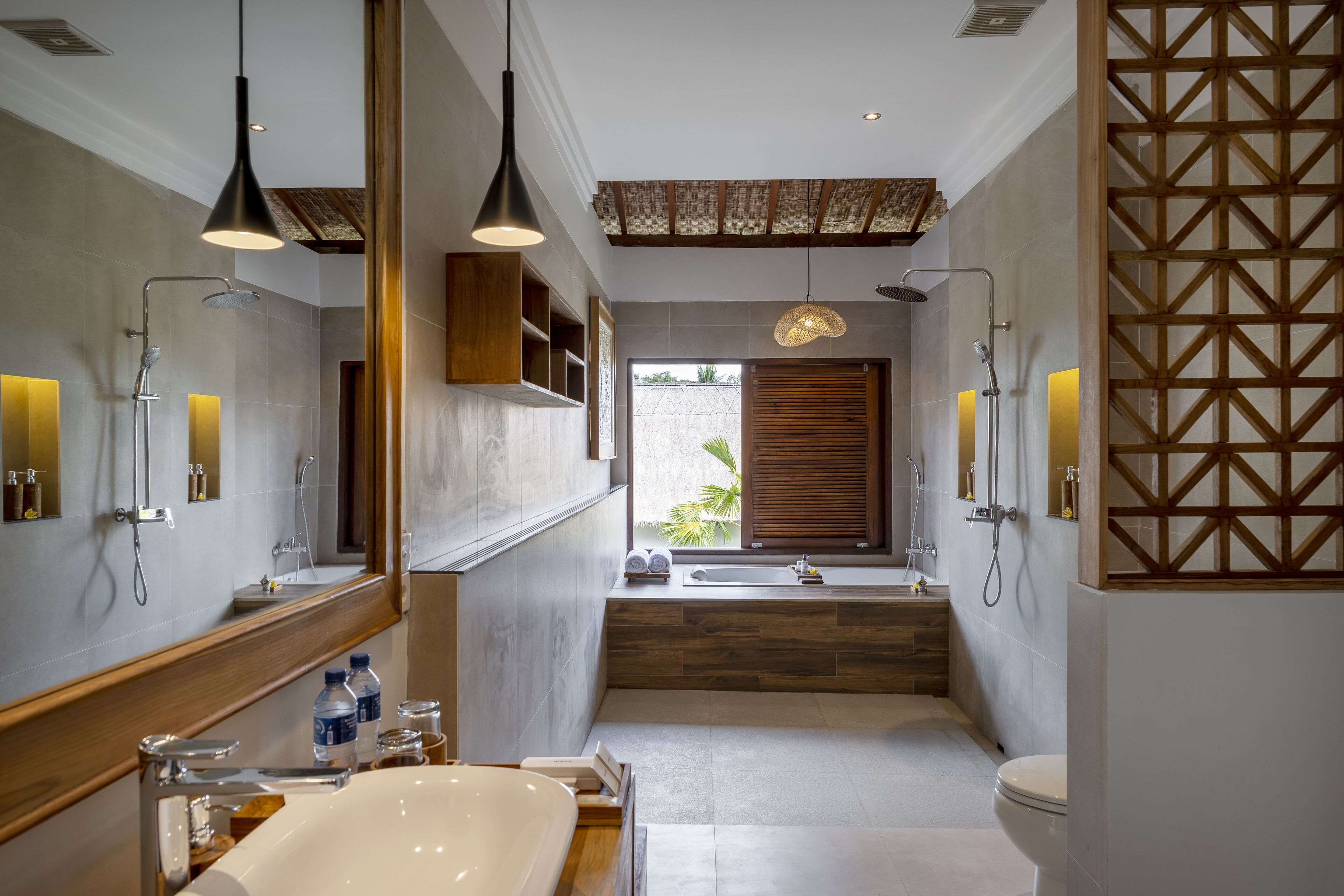 Een moderne badkamer met een groot bad, twee wastafels en een douche.