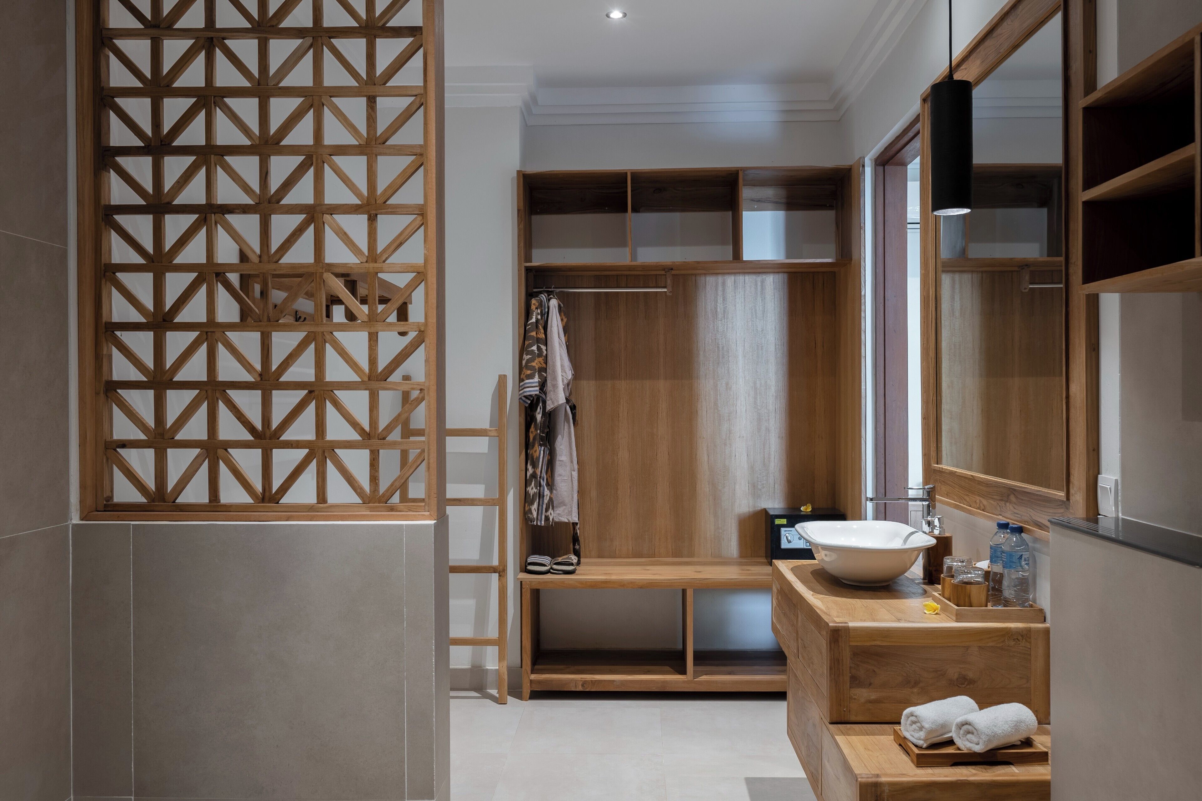 A modern bathroom with a wooden vanity, a large mirror, and a built-in shower area.