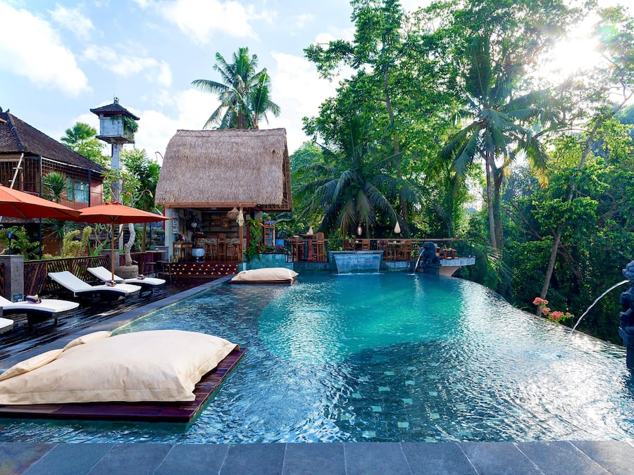 Een buitenzwembad, ligstoelen bij het zwembad