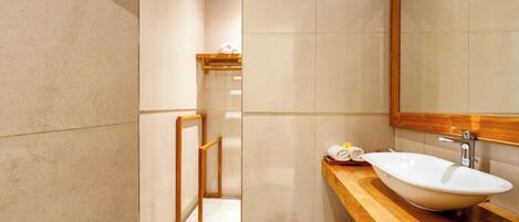 A modern bathroom with a large mirror, wooden vanity, and a freestanding bathtub.