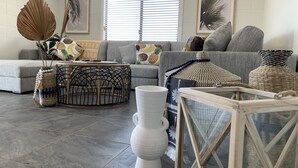 A modern living room with a grey sofa, a round coffee table, and decorative vases.