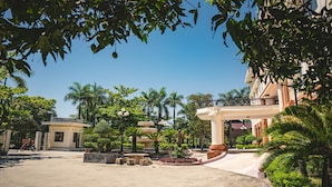 Un patio con palmeras, una fuente y un edificio con balcón.