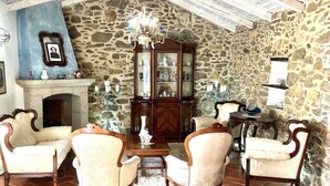 A cozy room with stone walls, a fireplace, and a wooden cabinet. - Li Funnesi Villa sleeps 4, 2 bathrooms, A.C and large garden in San Teodoro (San Teodoro)