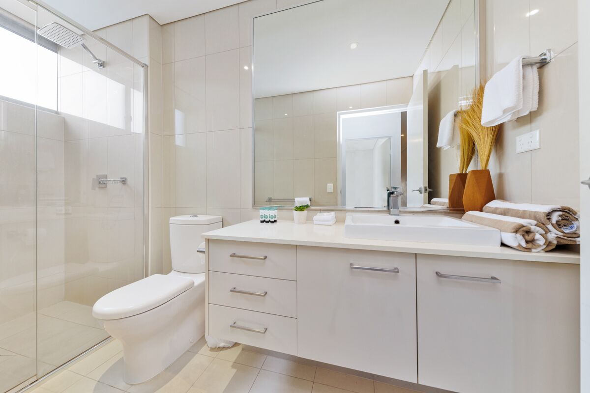 A modern bathroom with a toilet, sink, and shower.