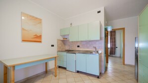 Una cuina moderna amb armaris de blau clar, una taula de fusta i un sòl de rajola.