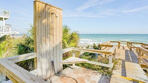 A wooden deck leading to a beach with a wooden structure, palm trees, and ocean views. - Oceanfront Top Floor Ocean Dunes, Bunk Room, Indoor/Outdoor Pools, Hot Tub, Tennis (Kure Beach)