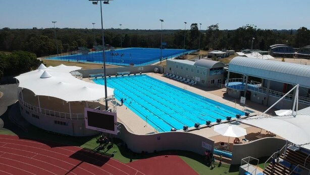 A swimming pool, a running track, and a covered spectator area. - Gold Coast Performance Centre - Hostel (Runaway Bay)