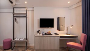 A modern hotel room with a desk, chair, and a television. - The Belamy House Managed by HII (Makati)