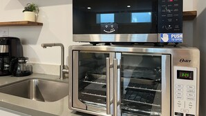 Une cuisine équipée d’un four en acier inoxydable, d’une machine à café et d’un évier.