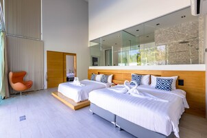 Un hotel moderno con dos camas, un espejo grande y vistas al exterior.