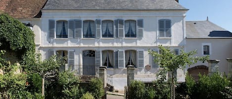 A two-story house with a garden in front.