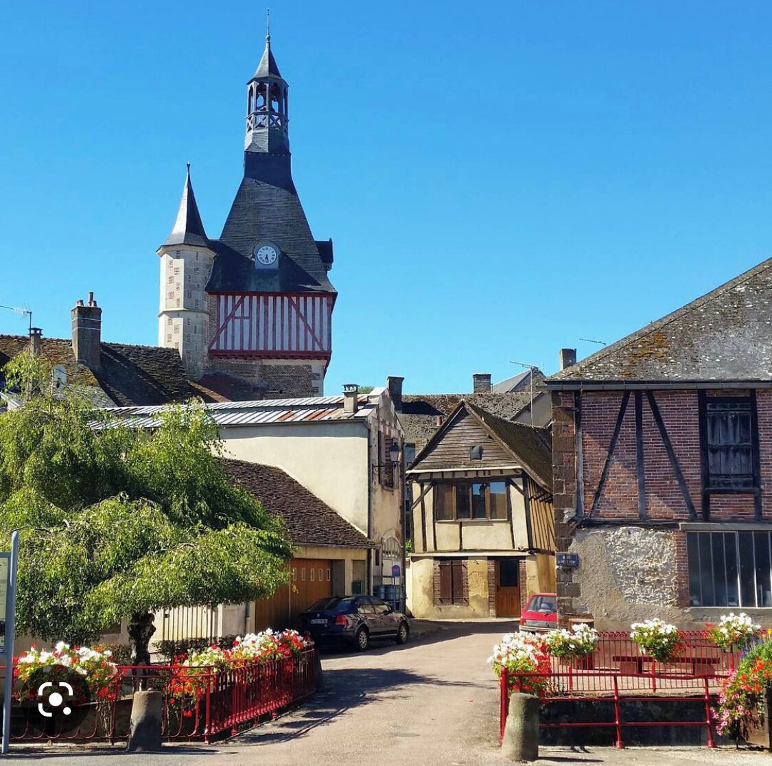Een traditioneel Europees dorp met een opvallende kerktoren, smalle straatjes en pittoreske gebouwen.