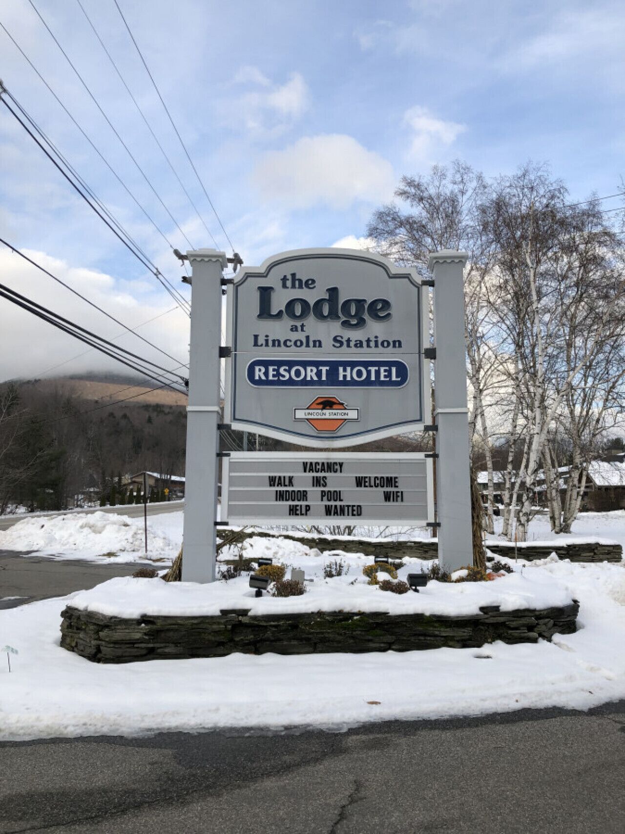 A sign for The Lodge at Lincoln Station Resort Hotel with amenities listed including walk-ins, indoor pool, and WiFi.