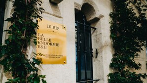 A sign for "10 BIS LA BELLE ENORMIE B&B" on a building facade with ivy. - La Belle Endormie B&B (Bordeaux)