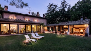A house with a patio area, outdoor seating, and a visible kitchen. - Splendid Villa Monte Quercione (Emilia-Romagna)
