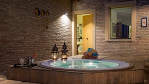 A hot tub with wooden benches, lanterns, and towels. - Splendid Villa Monte Quercione (Emilia-Romagna)