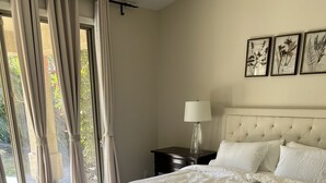 A bedroom with a large bed, a nightstand, a lamp, and a window with curtains. - RENT NOW!! 1st Time NEW Rental Grayhawk Luxury Home Near TPC Scottsdale Shopping (Scottsdale)