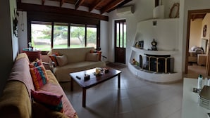 Uma sala de estar com sofá, mesa de centro e lareira.