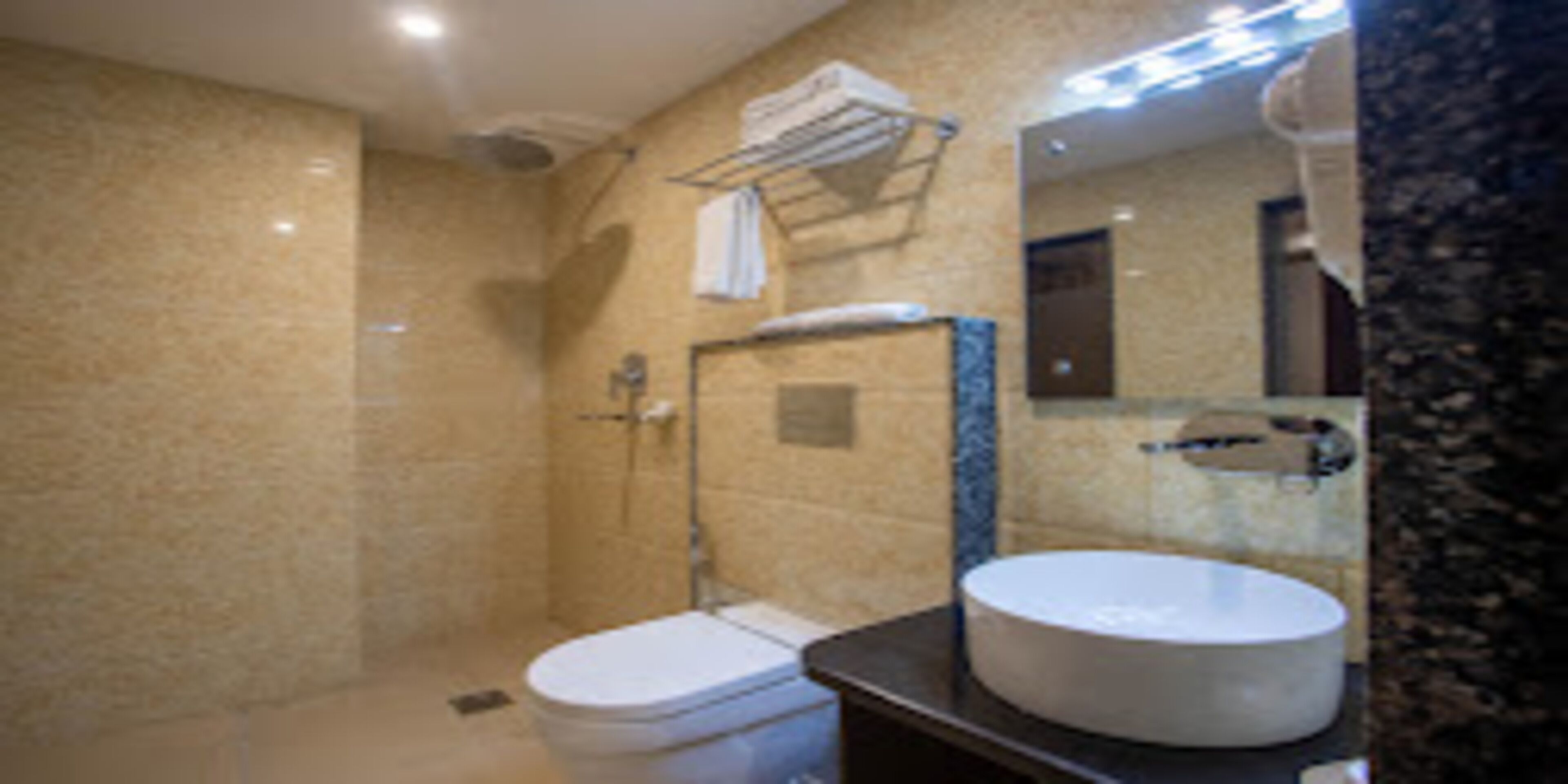 A bathroom with a toilet, sink, and mirror.