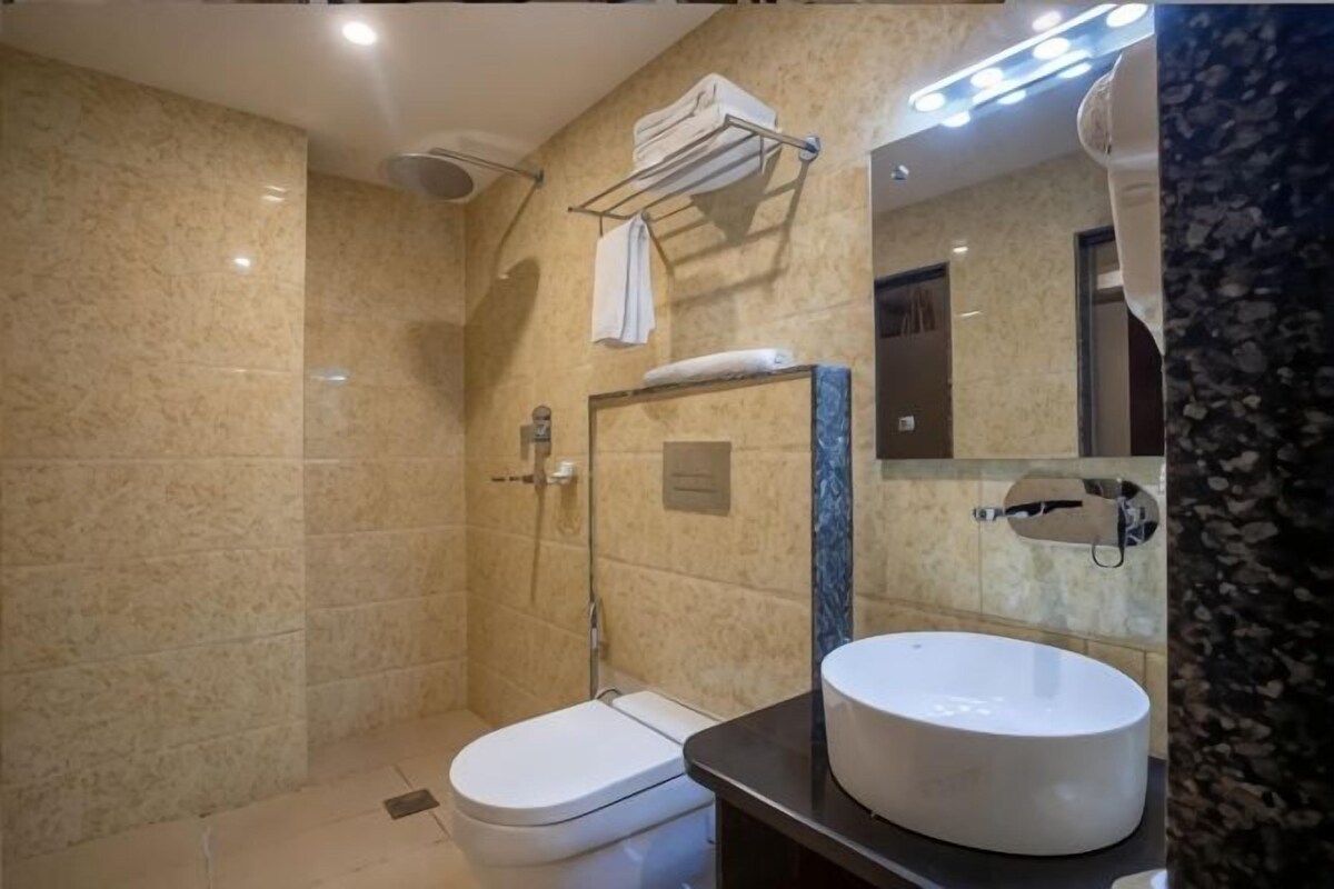 Une salle de bain comprenant des toilettes, un lavabo, une douche et un miroir.