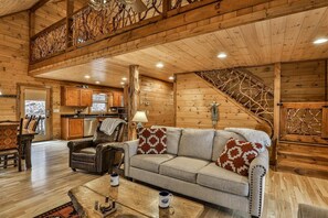 Un interior de madera con sofá, mesa de centro y una escalera.
