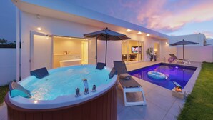 Een modern zwembadterras met een jacuzzi, ligbedden en parasols.