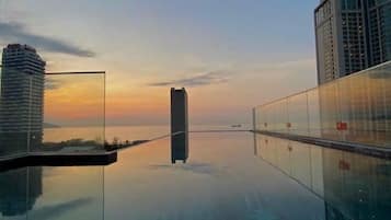 Una piscina al aire libre, sillones reclinables de piscina