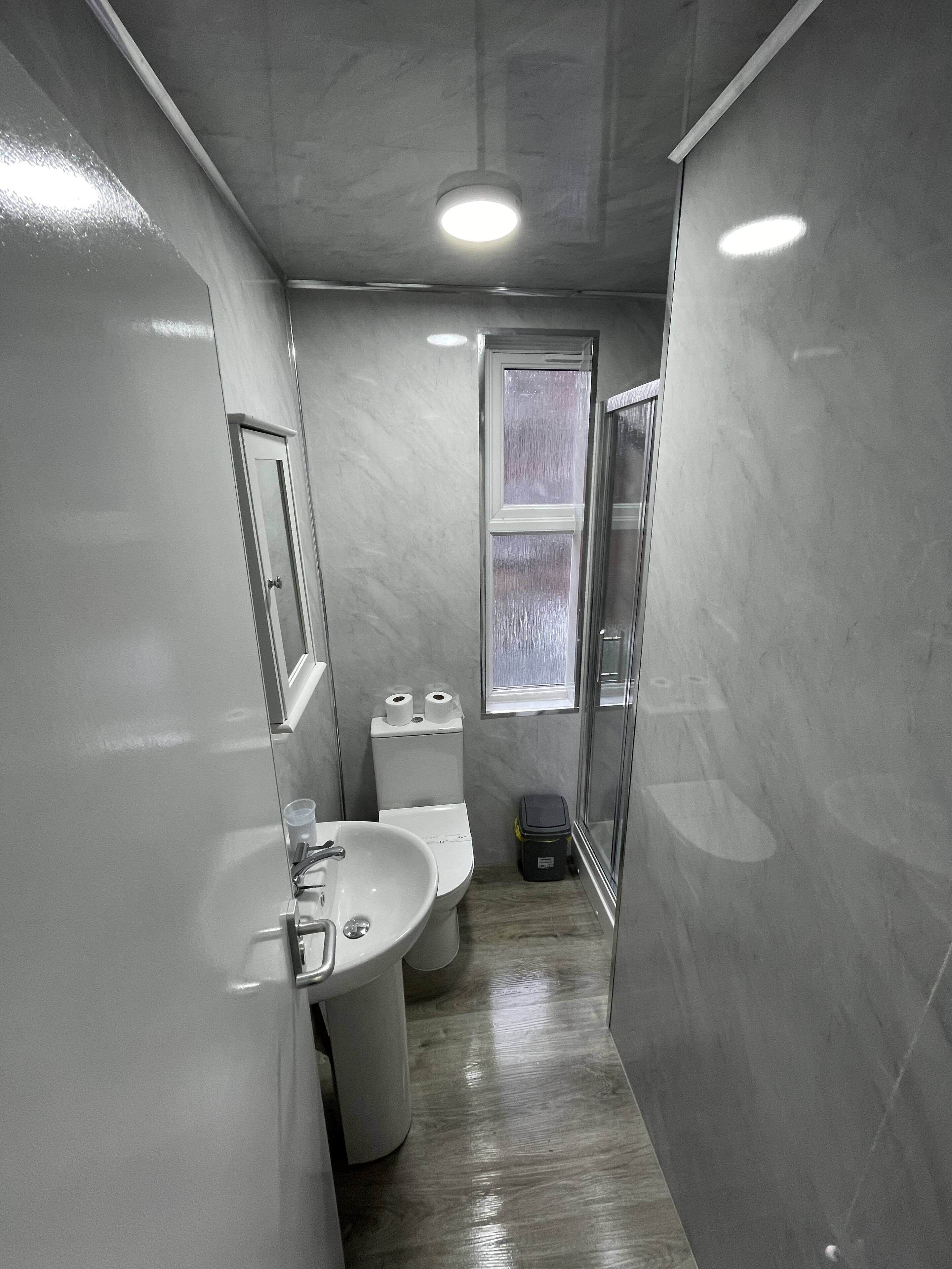 Un bagno piccolo ma funzionale, con lavandino, WC e zona doccia.