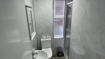 Un bagno piccolo ma funzionale, con lavandino, WC e zona doccia.