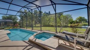 Une piscine extérieure couverte offrant une vue sur un lac et des arbres.