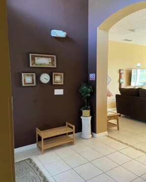 A living room with a brown wall, a wooden bench, a potted plant, and a couch.