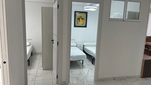 A hotel room with a bed, a nightstand, a wall-mounted picture, and a door leading to another room. - BELGICA, ESC-2, 4º-8 (Cullera)