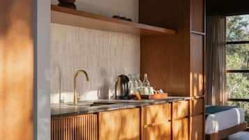 Une cuisine moderne dotée d’un plan de travail en bois, d’un robinet doré et d’un four encastré.