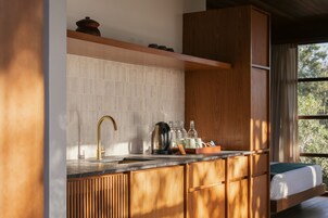 Une cuisine moderne dotée d’un plan de travail en bois, d’un robinet doré et d’un four encastré.