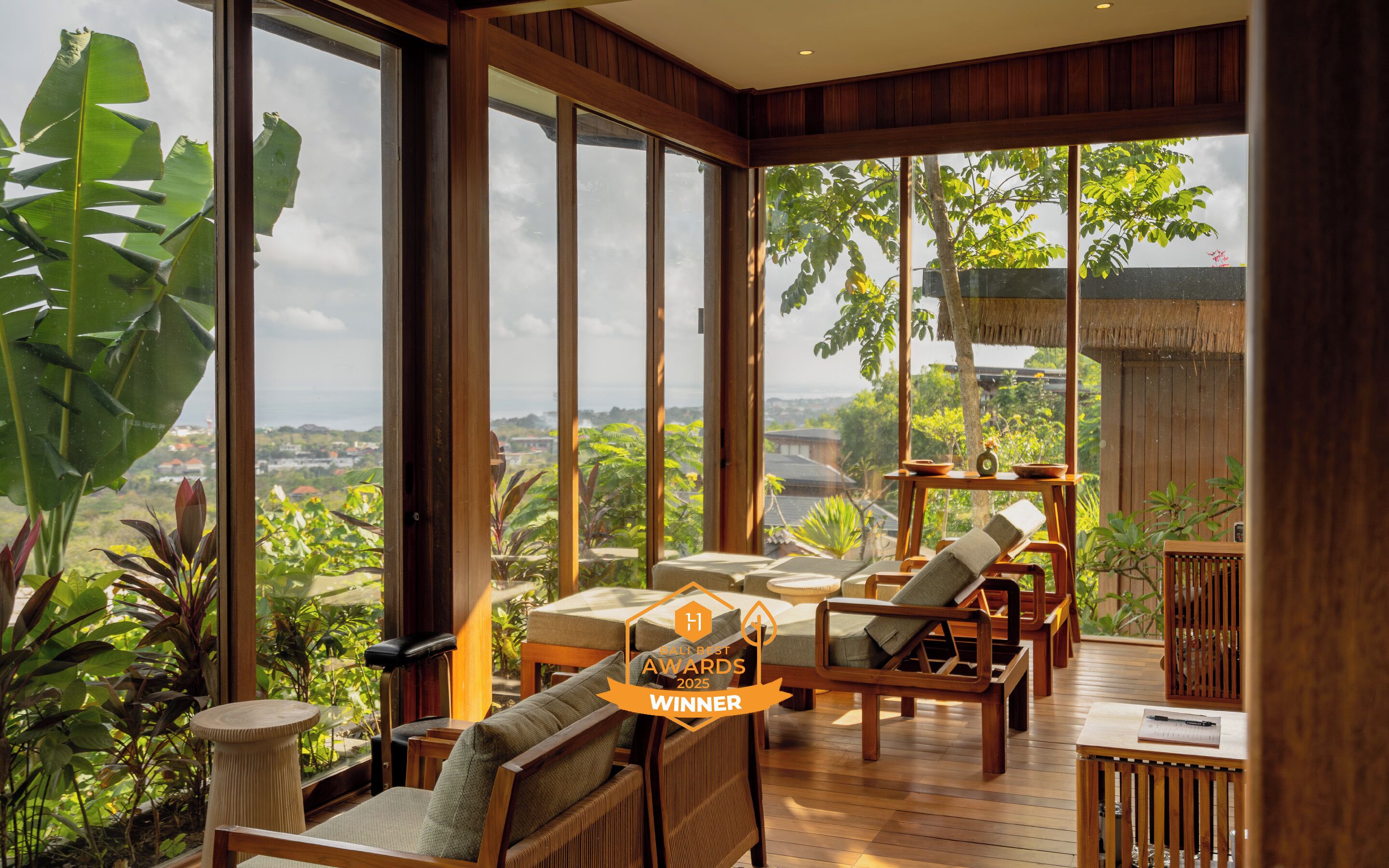 A spacious room with large windows, wooden furniture, and a view of the landscape.