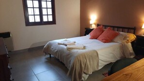 Ein Hotelzimmer mit Bett, Nachttisch, Fenster und Heizkörper.